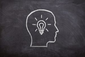 gezeichneter kopf in weiß mit einer glühbirne